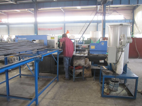 Two workers are operating the sucker rod machine.