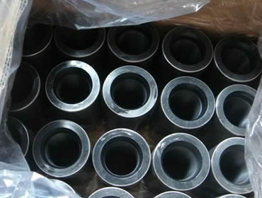 Several sucker rod couplings in the carton with plastic paper in the carton.