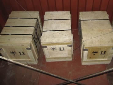 Four wooden boxes in the container and fastened by the steel wire rope. 